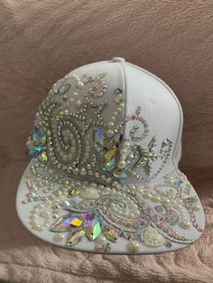 White and silver diamanté crystal festival hat Cap style, size adjustable   Festival hat  Great for weddings or hen dos or just for a fabulous diva !! Encrusted in diamanté's and pearls with appliqué lace and badges  Hand embellished using high quality crystal AB diamanté's and jewel stones.  Please contact me to discuss personalised hats at your request xx White Adjustable Baseball Cap For Party, White Snapback Party Hat, White Snapback Hat For Party, White Rhinestone Party Headpiece, White Adjustable Hat With Rhinestones, White Tall Crown Hat With Adjustable Fit, White Adjustable Rhinestone Hats, White Adjustable Hat With Tall Crown, Adjustable Crystal Headpiece With Rhinestones