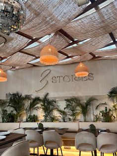 the interior of a restaurant with disco balls hanging from the ceiling and tables in front of it