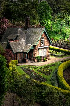 an aerial view of a house surrounded by hedges and trees in the background is a garden