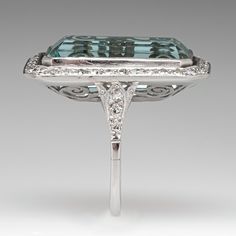 This mazing vintage cocktail ring is centered with one (1), bezel set, emerald cut natural aquamarine that is bordered with thirty-six (36), bead set, round single cut diamonds. The shoulders of the ring are each accented with three (3), bead set, round single cut diamonds. The gemstones are bordered with milgrain edging. The ring measures 28.9mm X 18.7mm at the top, rises 9.1mm above the finger, tapering to 1.7mm wide and 1.3mm thick at the base of the shank. It is currently a size 7. Rectangular Silver Emerald Ring For Formal Occasions, Rectangular Aquamarine Jewelry For Wedding, Rectangular Aquamarine Wedding Jewelry, Rectangular Emerald Ring With Accent Stones For Formal Events, Rectangular Emerald Ring With Accent Stones For Formal Occasions, Formal Emerald Ring With Diamond And Rectangular Stone, Luxury Aquamarine Octagon Ring, Art Deco Emerald Cut Diamond Jewelry, Formal Emerald Ring With Rectangular Diamond