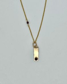 Indulge in luxury and elevate your style with our one-of-a-kind Gold Bar with Garnet Necklace. The delicate 4mm garnet cabochon adds a touch of sophistication to any outfit, making it the perfect accent piece for a chic and elegant evening. Don't miss out on this exclusive accessory, perfect for your next "little black dress" event. Formal Yellow Gold Garnet Necklace, Gold Garnet Necklace For Gift, Elegant Garnet Necklace With Natural Stones, Elegant Yellow Gold Garnet Necklace, Garnet Necklace Gold, Halo Earrings, Garnet Necklace, Gold Bar, Love Necklace