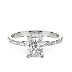 Elegant and elaborate. As the idealist type to enhance her incredible charm, this ring is the best option to accentuate the dazzling glamour of the emerald-cut center stone. Adorned with the shimmering stones pave shank, this ring will make a striking impression on your perfect wedding.Carat Weight: 1.55 ctStone Size: 5*7 mmStone Type: Jeulia® StoneNumber of Stones: 1 Stone Color: Diamond WhiteStone Shape: RadiantCarat Weight: 0.268 ctStone Size: 1.1,1.3 mmStone Type: Jeulia® StoneNumber of Ston Radiant Cut Diamond Emerald Promise Ring, Dazzling Baguette Cut Diamond Promise Ring, Dazzling Emerald Cut Emerald Ring In Diamond White, Dazzling Emerald Cut Diamond Promise Ring, Dazzling Emerald Cut Diamond Ring For Promise, Dazzling Diamond White Emerald Cut Emerald Ring, Dazzling Emerald Cut Emerald Ring With Diamond White Color, Silver Emerald Cut Ring With Pave Setting, Emerald Cut Diamond Promise Ring