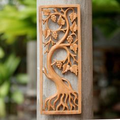 an intricately carved wooden panel with a tree on it