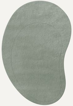 a round rug with an oval design on the top in light green color, made from soft cotton