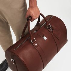 Luxury Cognac Travel Bag For Overnight Trips, Luxury Cognac Duffle Bag For Travel, Luxury Brown Weekender Bag For Business, Luxury Cognac Weekender Bag With Smooth Grain, Luxury Cognac Smooth Grain Weekender Bag, Luxury Cognac Travel Bag For Business Trips, Luxury Leather Weekender Bag In Cognac, Classic Textured Leather Weekender Bag For Business, Luxury Cognac Duffle Bag For Everyday