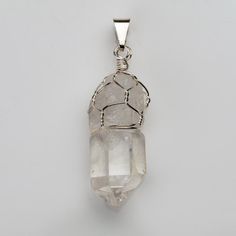 Gemmy transparent fully terminated clear quartz crystal pendant silver plated on top with bail. Clear quartz is highly prized for its ability to clear the mind of negativity to enhance higher spiritual receptiveness. It is considered the master of all healing crystals due to its ability to magnify or amplify healing vibrations of other crystals Stock photo is shown, similar piece will be sent 8.3 grams, 40mm x 14mm x 10mm Spiritual Clear Crystal Pendant Necklace, Spiritual Silver Quartz Crystals, Spiritual Silver Quartz Crystal Necklaces, Silver Quartz Crystals For Gifts, Silver Quartz Crystal Necklaces For Spiritual Style, Silver Healing Mineral Crystals, Spiritual Silver Quartz Crystal Necklace, Spiritual Silver Mineral Crystal, Silver Quartz Crystals For Healing