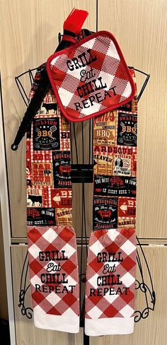 a red and white checkered scarf hanging on a rack in front of a door