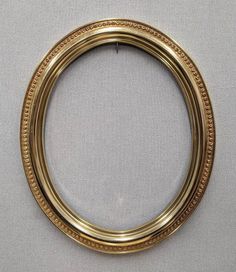 an oval gold frame with beaded edges on a gray background, in the shape of a circle