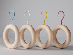 three wooden rings with different colored handles are lined up in a row on a gray background