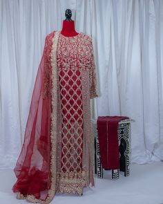 It has an all-machine embroidered base with gold tilla and has hand embellishment work on it on the front and sleeves. It is closed from the sides and has front slits. It is paired with an organza dupatta which is stitched with a gold border on all four sides. 4 pieces. Anarkali-style Embellished Sherwani With Traditional Drape, Traditional Unstitched Suit With Resham Embroidery For Reception, Long Traditional Wear With Dabka Work For Reception, Red Unstitched Suit With Intricate Embroidery For Reception, Long Sharara With Dabka Work For Reception, Long Sleeve Kundan Traditional Wear With Zari Work, Traditional Unstitched Suit With Straight Kurta For Reception, Traditional Festive Unstitched Suit For Reception, Anarkali Style Embellished Sherwani For Festive Occasions