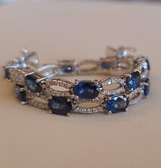 This is a simple diamonds and sapphires bracelet. 14 pieces of sapphires size 6×4 mm, total weight 7.70 carats. 141 pieces of diamonds total weight 0.70 carats. 18k white gold bracelet setting weight 8.50 grams. Sapphire Bracelets With Diamond Accents, Silver Sapphire Tennis Bracelet With Brilliant Cut, White Gold Sapphire Gemstone Tennis Bracelet, Oval Sapphire Bracelets In White Gold, Oval Sapphire Bracelet In White Gold, Oval White Gold Sapphire Bracelet, White Gold Sapphire Bracelet In Fine Jewelry Style, Elegant Sapphire Tennis Bracelet With Brilliant Cut, White Gold Sapphire Diamond Bracelet