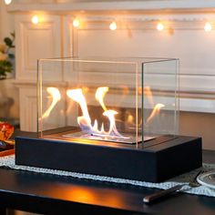 a glass case with flames inside on a table