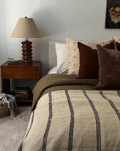 a bedroom with a bed, nightstands and pictures on the wall above it is shown