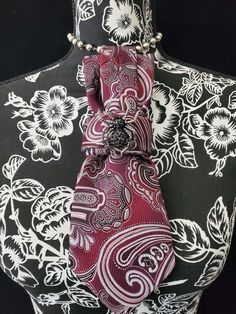 This Burgundy and White Paisley Necktie Necklace is made with a woven silk tie, and features a Black Rhinestone Spider Brooch strung on your choice of an adjustable Rosary Chain Ribbon Tie Pearl Necklace or an adjustable Elastic Band. The soft, comfortable fabric sits perfectly on any size chest, while the adjustable necklace feature allows you to customize the fit to your liking. Measuring at a versatile length, this necktie necklace is designed to be a one-size-fits-all. View all Women Tie's: Classic Jewelry With Ties For Parties, Elegant Adjustable Neckwear For Gifts, Elegant Adjustable Neckwear As Gift, Elegant Adjustable Neckwear As A Gift, Elegant Silver Tie As A Gift, Elegant Burgundy Tie For Formal Occasions, Elegant Red Neckwear For Gift, Elegant Red Neckwear As A Gift, Elegant Adjustable Formal Neckwear