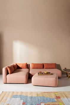 a pink couch sitting on top of a rug in a living room