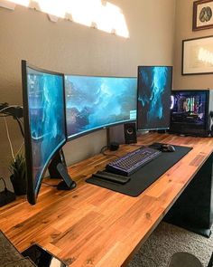 three computer monitors sitting on top of a wooden desk