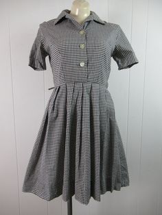 "Vintage 1950s sundress, dress. Made of black and white gingham check cotton. Has a shirt collar, button front and side zipper. Belt lops, but no belt. Made by Markstan, Schoolmaid. About a size small. Actual measurements are: 35\" around the bust line 27\" around the waist large hips 15\" shoulder seam to shoulder seam 9.5\" shoulder seam to cuff 35\" overall length In excellent condition with a 1\" seam separation(photo)." Retro Cotton Plaid Dress For Picnic, Vintage Fitted Plaid Dress For Picnic, Fitted Vintage Plaid Dress For Picnic, Retro Short Sleeve Plaid Gingham Dress, Retro Gingham Plaid Cotton Dress, 1950s Style Gingham Cotton Dress, Vintage Cotton Plaid Dress, Vintage A-line Plaid Dress, Vintage Buttoned Dresses For Picnic