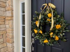 a wreath with lemons hanging on the front door