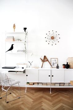 a room with a desk, chair and shelves on the wall next to each other