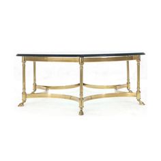 a gold and black glass table with two legs on each side, in front of a white background