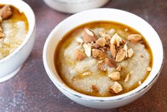 two white bowls filled with oatmeal and nuts