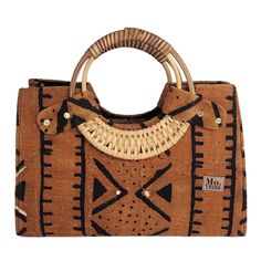 Introducing the Nasika Tote, a stunning handbag crafted from rich mudcloth. This traditional Malian fabric is renowned for its unique texture and cultural significance, making each bag a wearable piece of art. The intricate patterns and earthy tones of the mudcloth create a sophisticated look that's both elegant and eye-catching. With its spacious interior, sturdy cane handles, and inner pocket, this bag is as functional as it is beautiful. Every purchase supports women from low-income weaving c Brown Handwoven Bag With Round Handle, Traditional Top Handle Bag In Natural Color, Traditional Top Handle Shoulder Bag In Natural Color, Bohemian Brown Bags With Round Handle, Eco-friendly Brown Shoulder Bag With Round Handle, Traditional Natural Color Top Handle Shoulder Bag, Traditional Natural Color Top Handle Bag, Traditional Natural Top Handle Shoulder Bag, Handmade Brown Bag With Round Handle