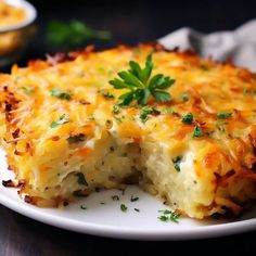 a cheesy dish on a white plate with parsley