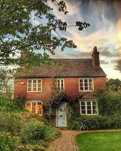 an old brick house with ivy growing on it's roof and windows in the front