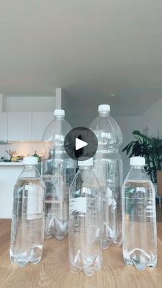 three large plastic water bottles sitting on top of a wooden table