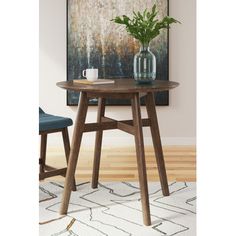 a wooden table with two chairs and a vase on top of it in front of a painting