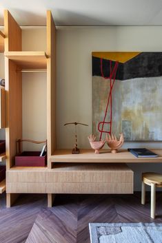 a living room with wooden furniture and paintings on the wall above it, along with other items