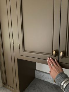 a person's hand reaching into a cabinet door