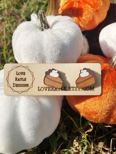 two stuffed animals sitting next to each other in the grass with a tag that says love kate designs