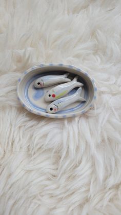 three toothbrushes in a blue and white bowl on a furry surface with fur