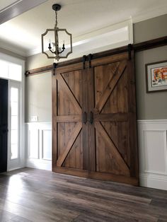 an open barn door in the middle of a room with wood floors and white walls