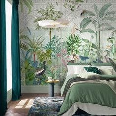 a bedroom decorated in green and white with tropical wallpaper