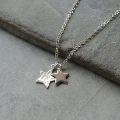 "Sterling silver Star necklace with two star charms. The first star measures 10 mm and has been gently hammered so it reflects the light and glistens when the light hits it. The second star measures 8 mm and is plain shiny silver. They suspend from a sterling silver Rolo chain in a choice of 14\",15\". 16\", 17\" or 18 inches. All components are 925 sterling silver. Your necklace will arrive in a gift box." Silver Star Charm Necklace, Silver Necklaces With Star Charm, Silver Pendant Charm Necklaces With Star Charm, Sterling Silver Star Charm Necklace, Silver Star-shaped Metal Necklace, Simple Silver Necklace, Aesthetic Pleasing, Homemade Jewellery, Simple Necklaces