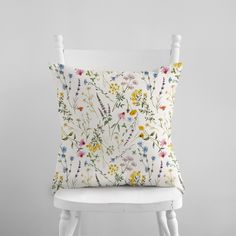 a white chair with a floral pillow on it