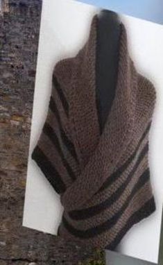 a brown and black knitted shawl hanging on a wall