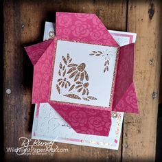 some cards are stacked on top of each other and one has a pink envelope with gold foil