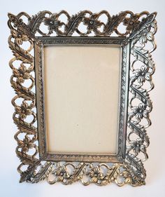 an ornate silver frame with flowers and leaves on the edges is shown against a white background