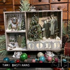 an old fashioned christmas display with ornaments and other items in it's shadow box