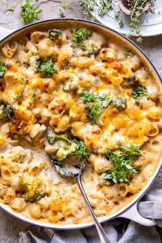 a casserole dish filled with macaroni and cheese, topped with broccoli