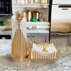 a gold and white napkin holder sitting on top of a marble counter