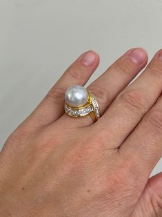 An 18 karat yellow gold and platinum ring set with a 13.1mm South Sea pearl, and approximately 1.34ctw of G.VS diamonds. Retail is $24,100. DESIGNER: Assael MATERIAL: 18k Yellow Gold / Platinum GEMSTONES: Pearl, Diamond DIMENSIONS: Ring size 6.5, Top is 18mm wide. MARKED/TESTED: 750, Cummings, Assael, PT950 WEIGHT: 20 grams CONDITION: Previously Owned / Excellent Condition Luxury Diamond White Brilliant Cut Pearl Ring, Exquisite Diamond Pearl Ring With Prong Setting, Luxury Brilliant Cut Pearl Anniversary Ring, Diamond Pearl Ring With Pave Setting For Formal Events, Diamond Pearl Ring With Pave Setting For Formal Occasions, Gold Pearl Ring With Diamond Prong Setting, Formal Diamond Pearl Ring With Pave Setting, Gold Diamond Pearl Ring With Prong Setting, Formal Yellow Gold Pearl Ring With Brilliant Cut