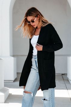 Stay extra cozy and fashionable this fall season while wearing this solid Black Duster Cardigan, a wardrobe staple! Introducing our Solid Black Oversized Duster Cardigan. This cardigan features drop shoulders, front pockets, and an open front design. The oversized fit and ribbed detailing add a touch of style and comfort to any outfit. Layer it over a basic tank top or bodysuit and then pair with jeans, ankle booties, and a matching crossbody bag for an elevated boho chic look! Oversized Solid Sweater Coat With Pockets, Oversized Sweater Coat With Pockets, Trendy Relaxed Fit Cardigan With Pockets, Oversized Fall Sweater With Pockets, Open Front Sweater Coat With Pockets For Fall, Trendy Open Front Solid Sweater Coat, Trendy Open Front Sweater With Pockets, Oversized Open Front Solid Sweater Coat, Trendy Solid Open Front Sweater Coat