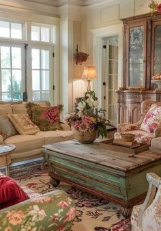 a living room filled with lots of furniture and flowers on top of the coffee table