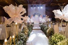 the aisle is decorated with flowers and candles