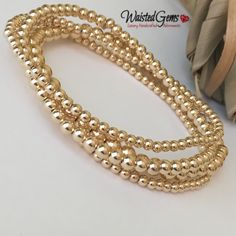 "14k Gold Filled Beaded Bracelet is handcrafted with 14K rose gold filled or 14K yellow gold filled or sterling silver smooth round 2.5mm, 3mm, 4mm & 5mm beads strung on a durable elastic cord a crimp cover bead is used to cover the elastic knot for a seamless finish this one bead will have a seam. These are beautiful, elegant, and modern pieces. They are great for stacking or wearing alone. These bracelets are sold Individually and come in a cute brand box ready for gift giving. If a full s Gold Stackable Beaded Bracelets, Gold Rondelle Bracelets, Rose Gold Bracelets With Gold Beads, Gold Hand-strung Jewelry For Wedding, Rose Gold Bracelet With Gold Beads, Gold Hand-strung Wedding Jewelry, Gold Stackable Charm Bracelet With Round Beads, Gold Rondelle Pearl Bracelet Gift, Gold Bracelets With Polished Round Beads