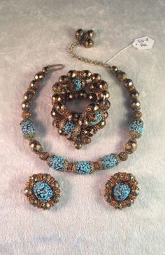 "This is a beautiful and stunning Hobé parure consisting of a necklace, earrings and wrap bracelet circa 1950s. All pieces are made from faceted gold glass beads, amber colored artglass beads covered with specks of turquoise glass, as well as round tangerine/orange rondelles and filigree caps throughout - a gorgeous combintaion of color and detail! The necklace measures 12\" with a 3\" extender and the beads are strung on fine chain. The bracelet is also in good condition, apart from one small d Turquoise Czech Glass Jewelry With Spacer Beads, Turquoise Czech Glass Jewelry With Faceted Beads, Turquoise Faceted Beads Jewelry In Czech Glass, Turquoise Czech Glass Round Beads Jewelry, Turquoise Czech Glass Bead Jewelry, Turquoise Czech Glass Jewelry For Party, Party Jewelry In Turquoise Czech Glass, Turquoise Czech Glass Party Jewelry, Elegant Turquoise Jewelry With Faceted Beads